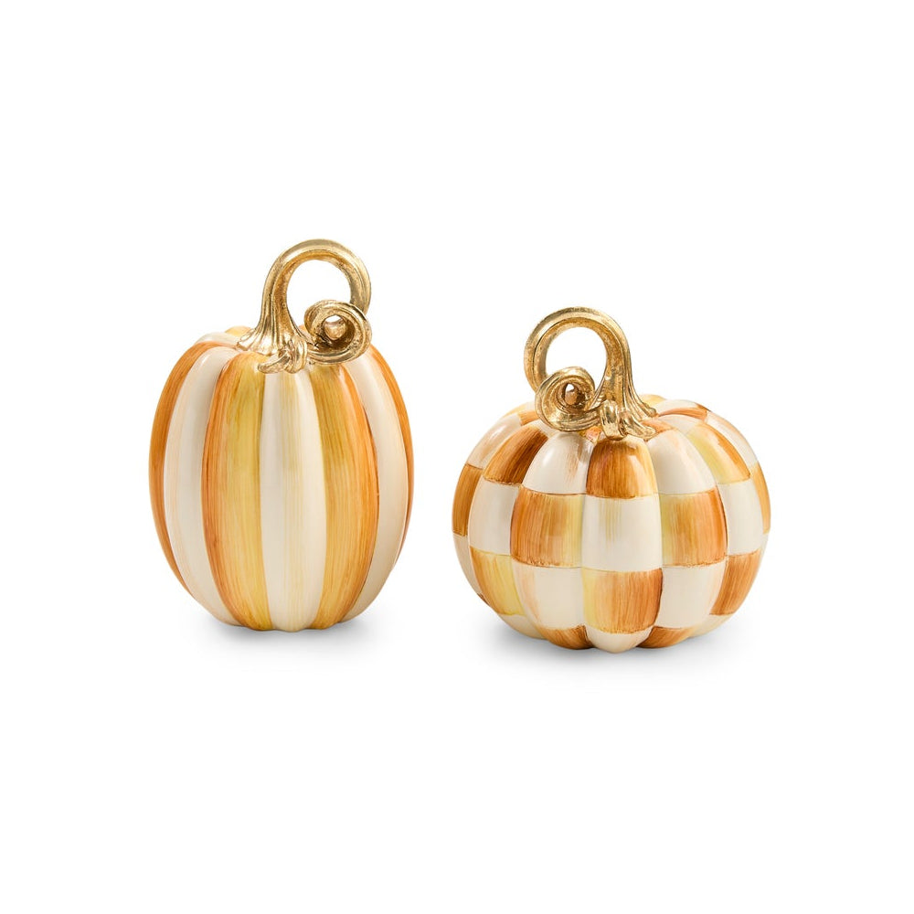 Two small decorative pumpkins with gold-tone loops at the top, shown on a clean white background. One pumpkin has vertical orange and cream stripes, and the other has a checkered pattern of orange and cream squares.