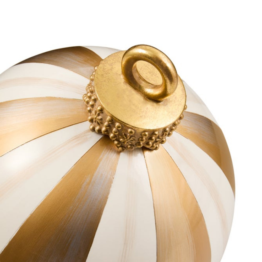 A close-up of a decorative ornament featuring alternating metallic gold and cream-white stripes, topped with an ornate gold cap and hanging loop against a plain white background.