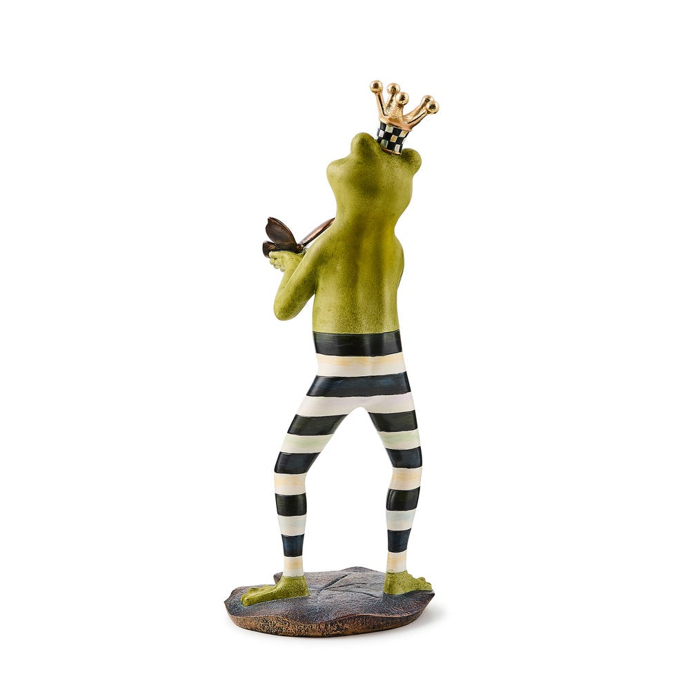 A photo of the back of a frog figurine with a crown and striped pants holding a butterfly on a white background.