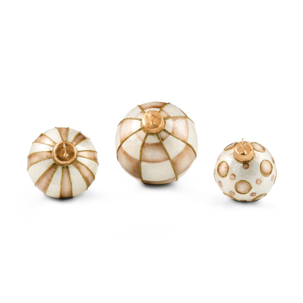 Three decorative spherical ornaments with cream and tan marbled patterns and gold metallic accents, arranged on a plain white background.