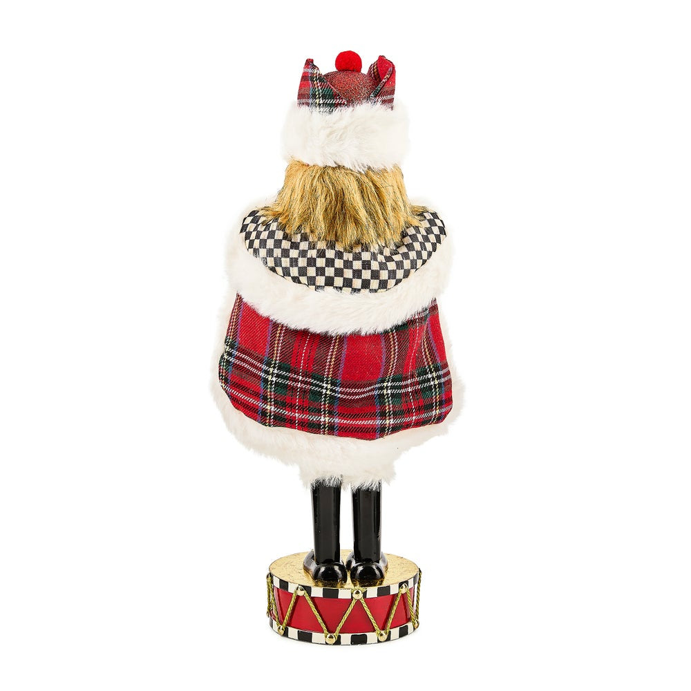 Decorative figure of a Scottish dancer with tartan kilt and hat on a white background.