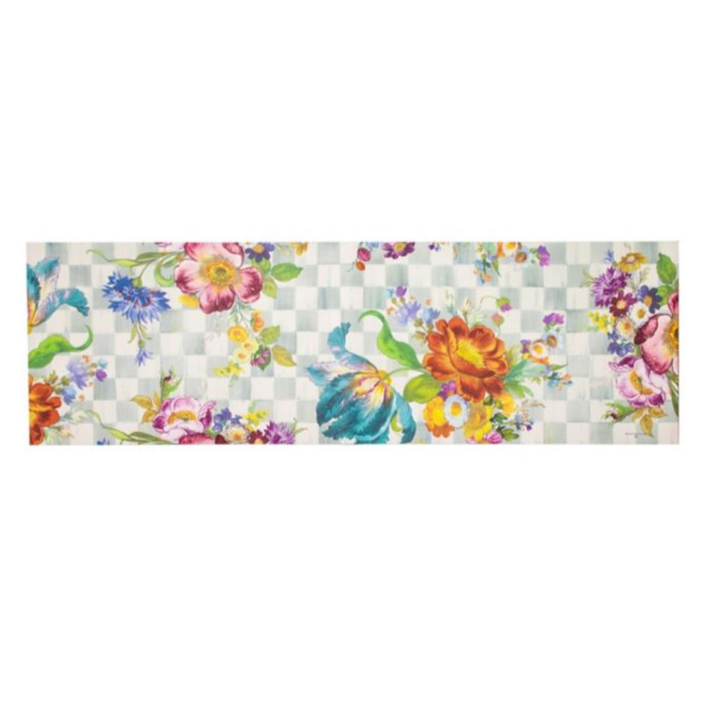A large sized 2' 6" x 8' colorful floral design doormat on a grey checkered background 