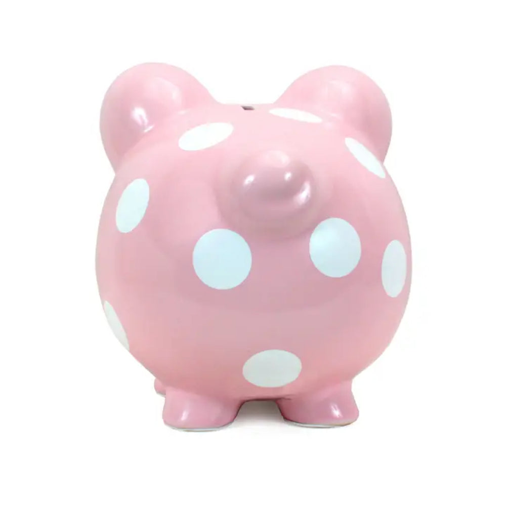 A pink ceramic piggy bank with white polka dots, photographed against a plain white background.