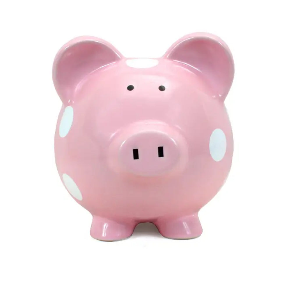 A pink ceramic piggy bank with white polka dots, photographed against a plain white background.