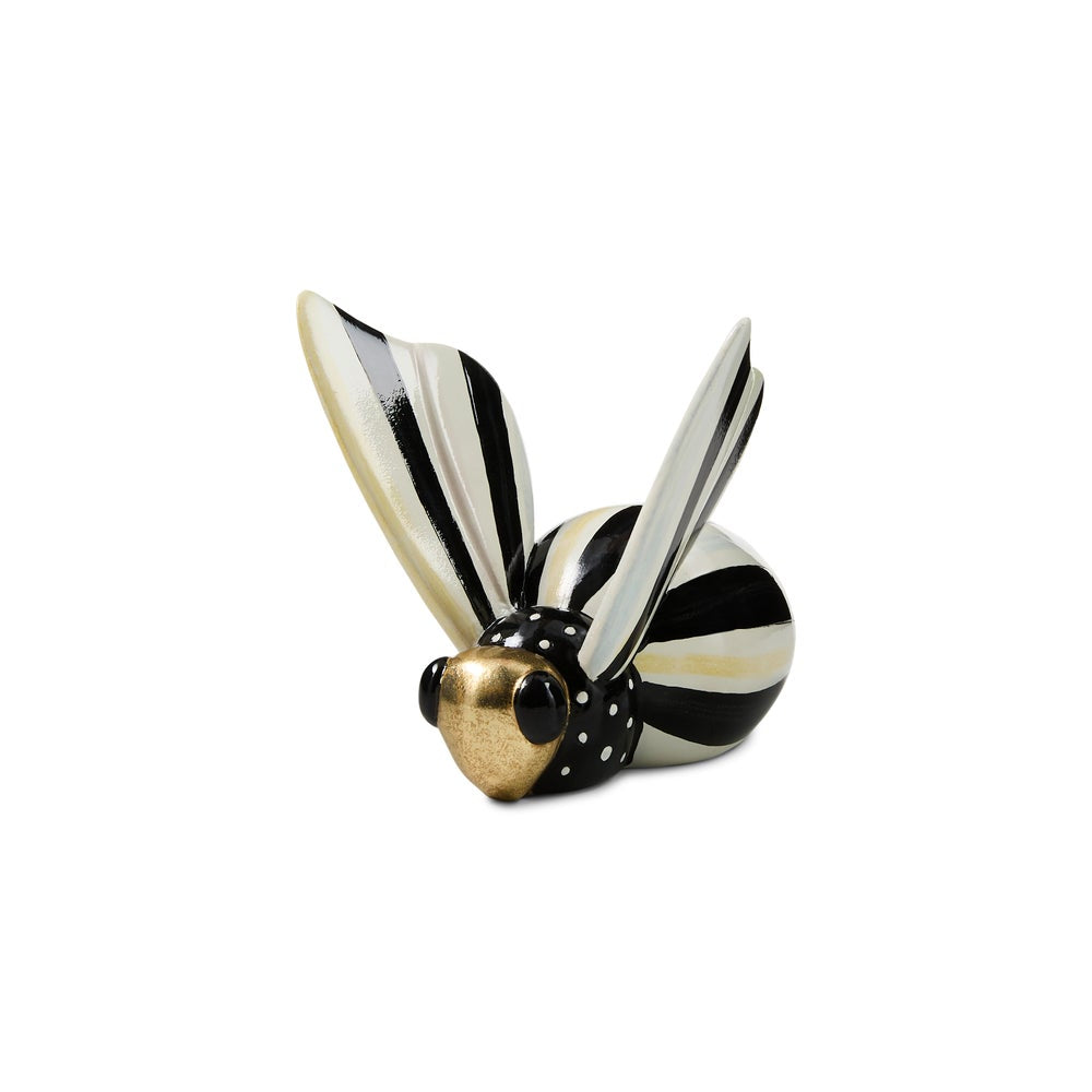 A decorative insect figurine resembling a beetle or bumble, featuring black and cream-white striped wings and body segments, with a metallic gold head and black polka-dot collar, set against a plain white background.
