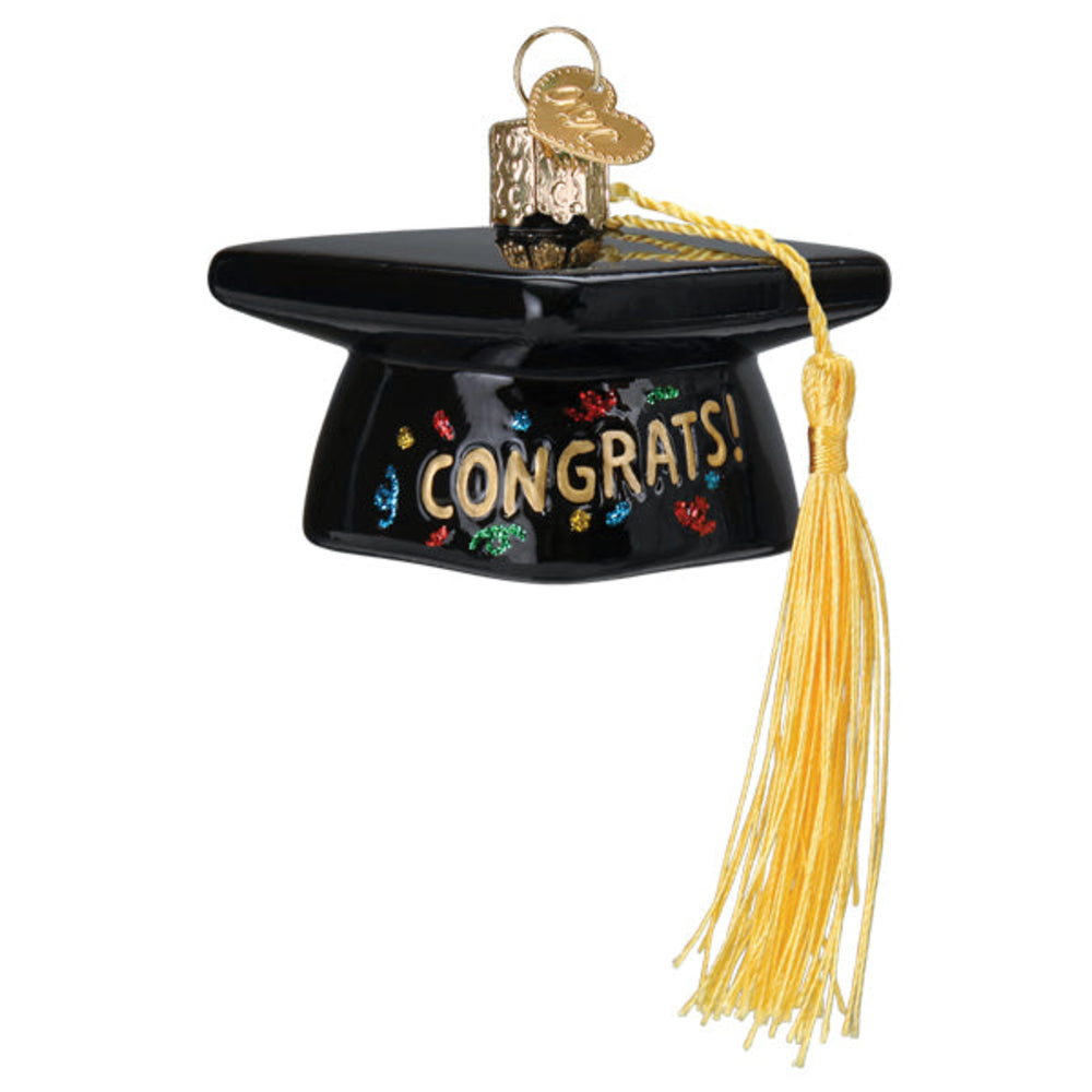 Glass ornament in the shape of a graduation cap that reads "CONGRATS!" across the front and has a yellow tassel on a white background.
