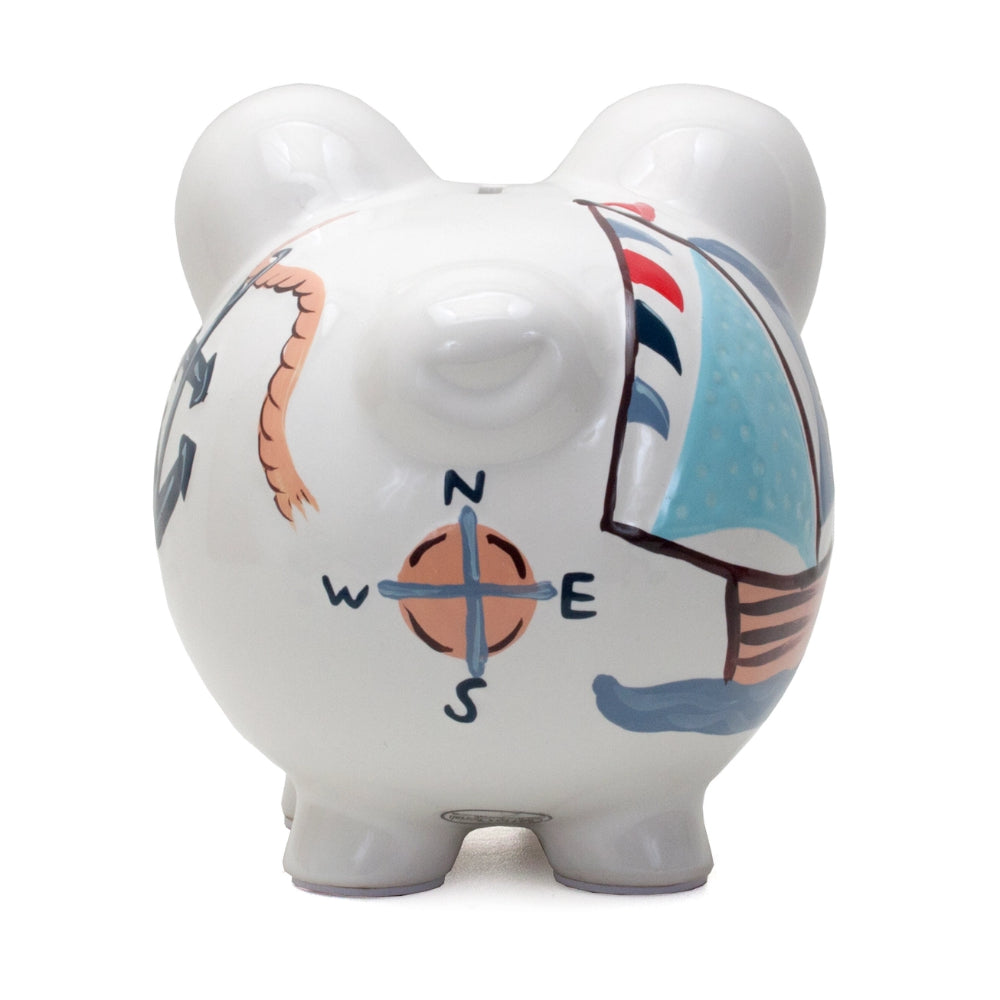 A photo of the back of an white piggy bank with compass design on a white background