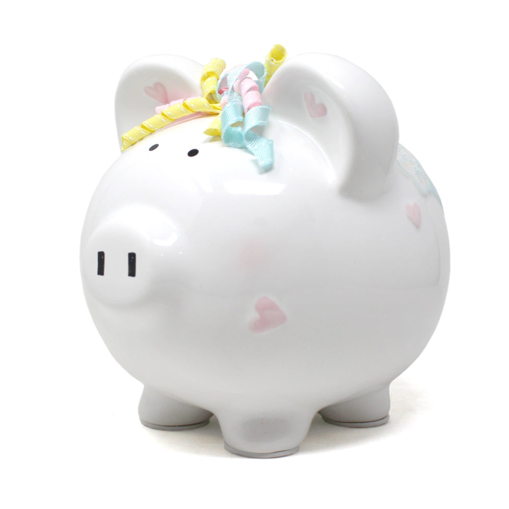 White piggy bank with a unicorn design and rainbow hair on a white background