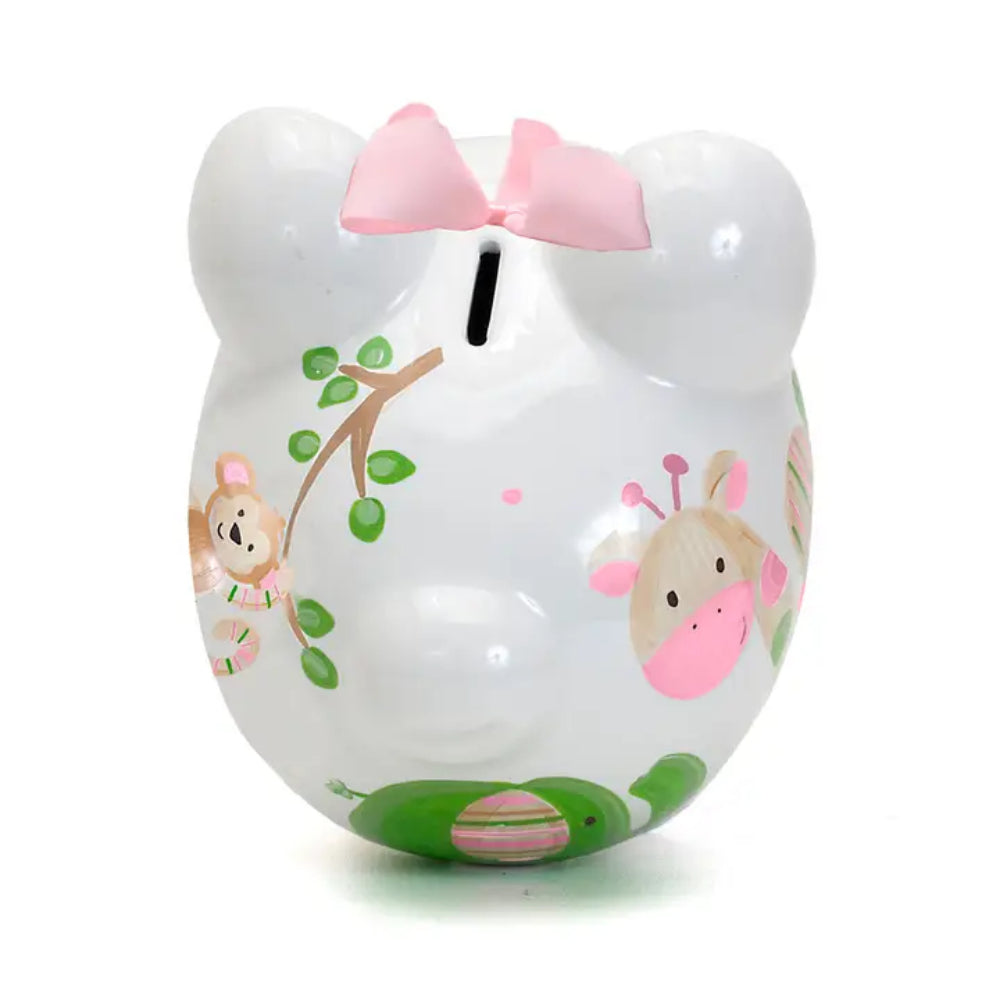 Photo of the top back of a white piggy bank with pink bow, monkey design, and green leaves on a white background