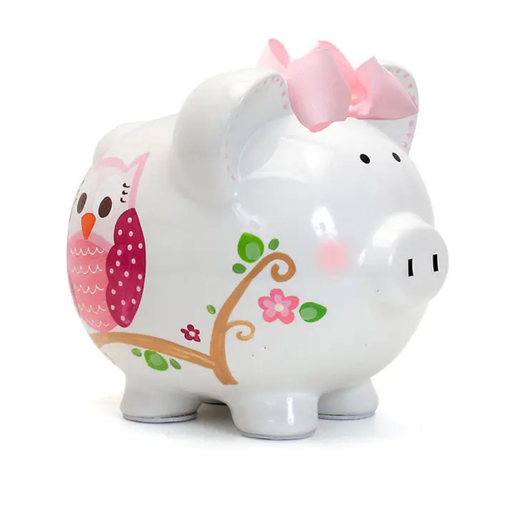 White piggy bank with owl design and pink bow on a white background