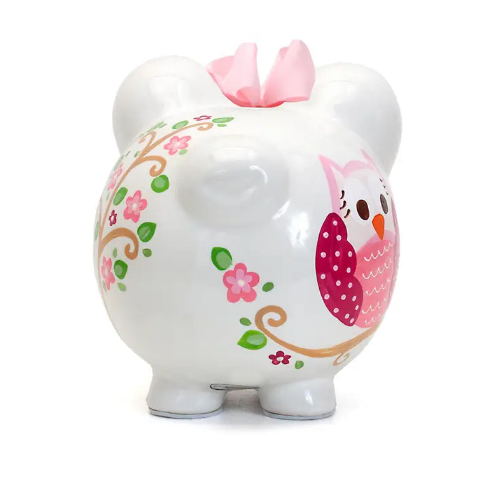 Decorative piggy bank with owl and floral designs on a white background