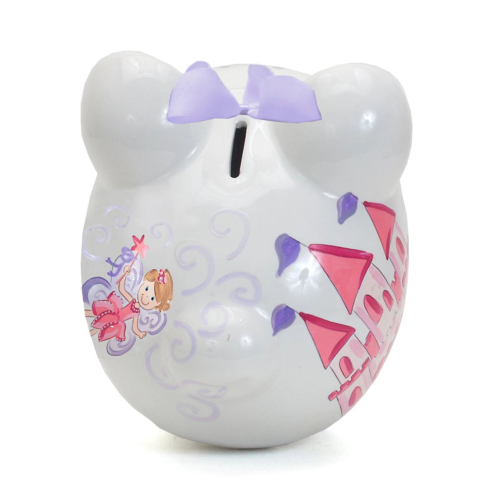 Top photo of a white piggy bank with a pink fairy design and pink castle and purple bow on a white background