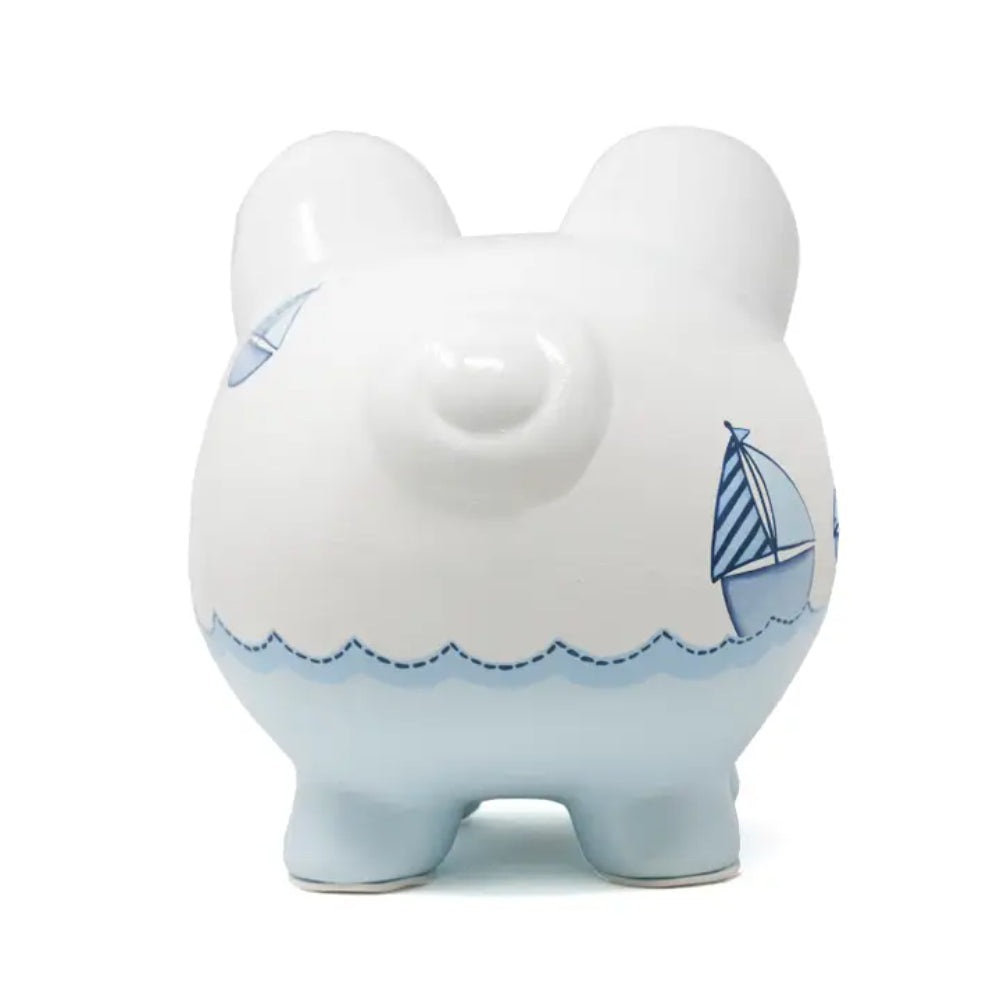 White piggy bank with blue accents and sailboat design on a white background