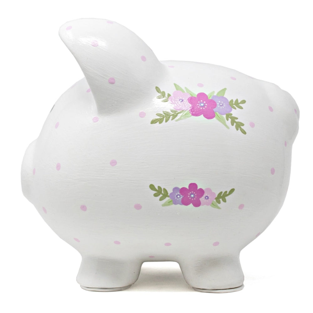 A piggy bank with purple polka dots and floral designs on white background. 