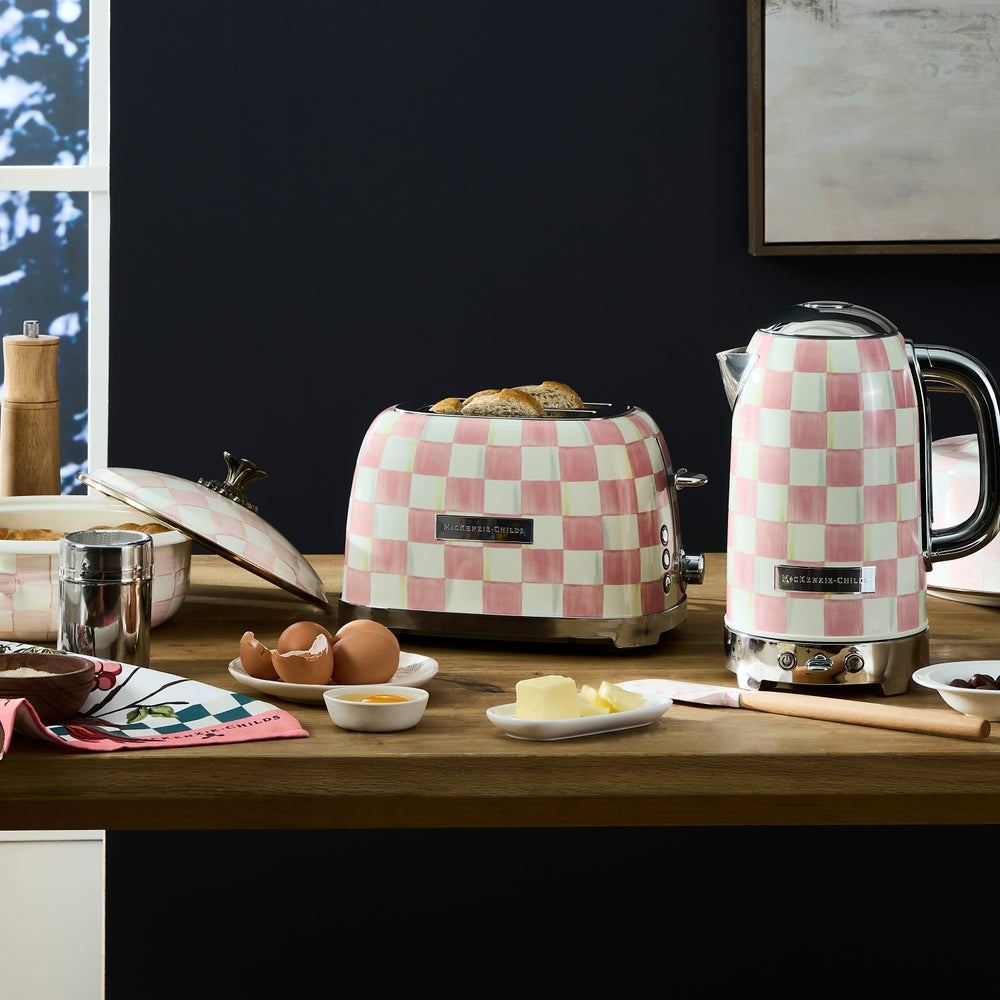 Checkered toaster and kettle on a kitchen counter with food items.