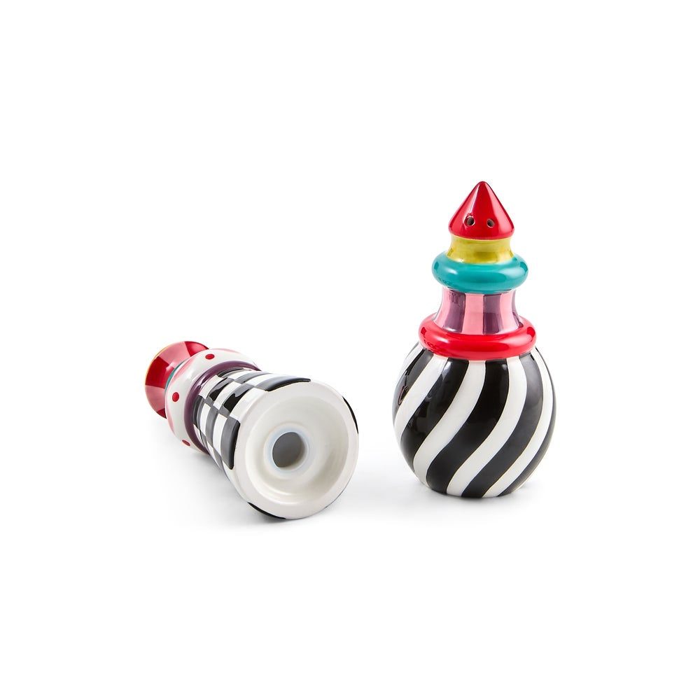 Two small decorative toy-like objects on a clean white background. One is lying on its side, showing a white base with black diagonal stripes and a red top with white polka dots.