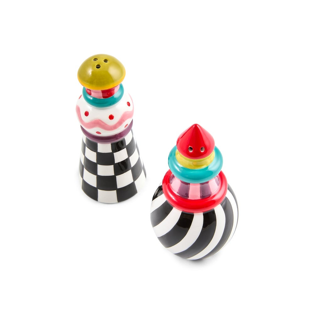 A pair of novelty pepper and salt shakers with whimsical, colorful designs. One shaker features a black and white checkered pattern with a yellow top, while the other has a black and white striped body with a red top and colorful accents.