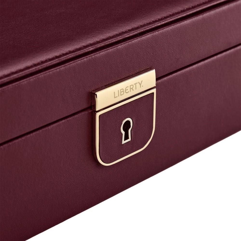 Close-up of a burgundy jewelry box with a gold lock and 'Liberty' branding.