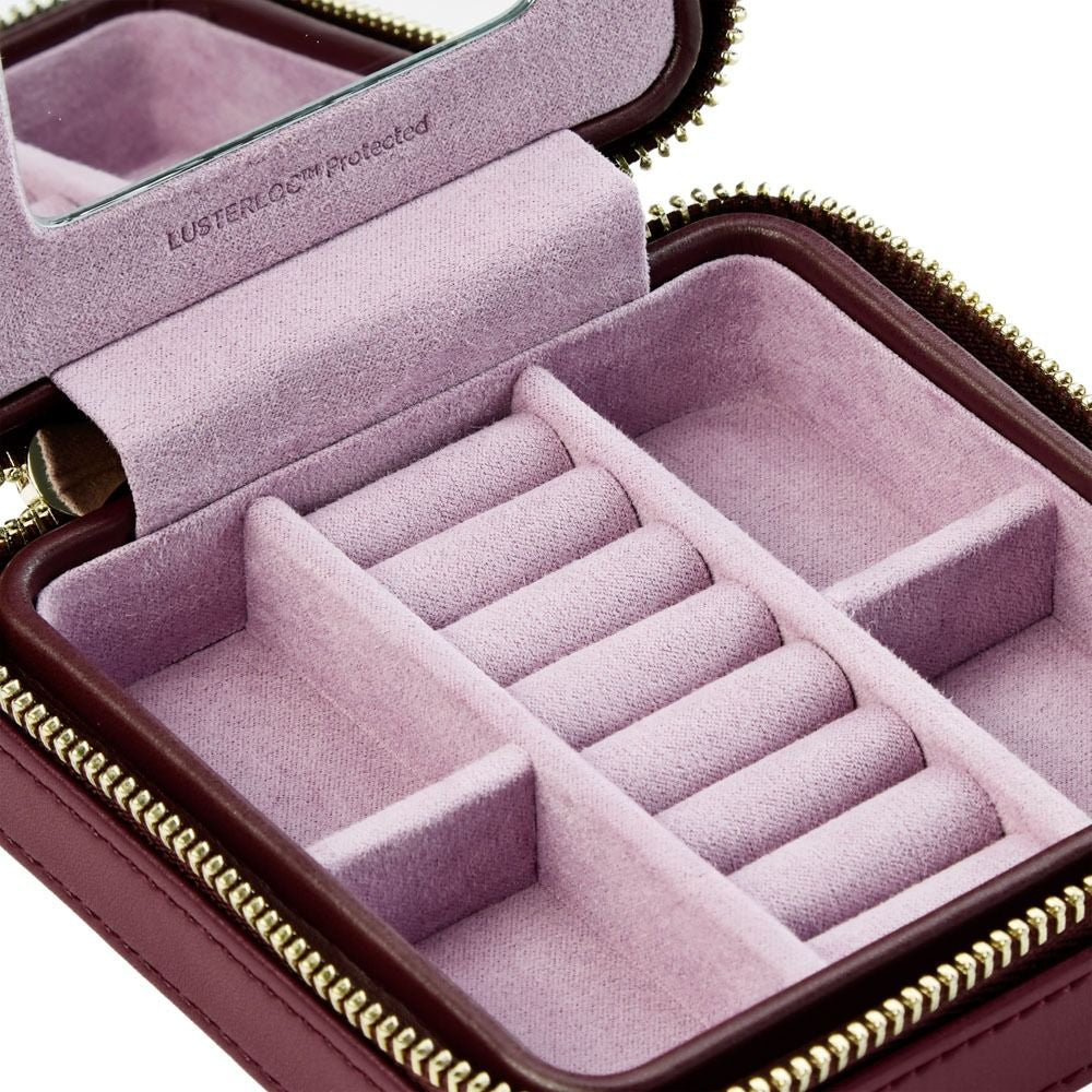 Pink jewelry case with compartments for rings and necklaces on a white background