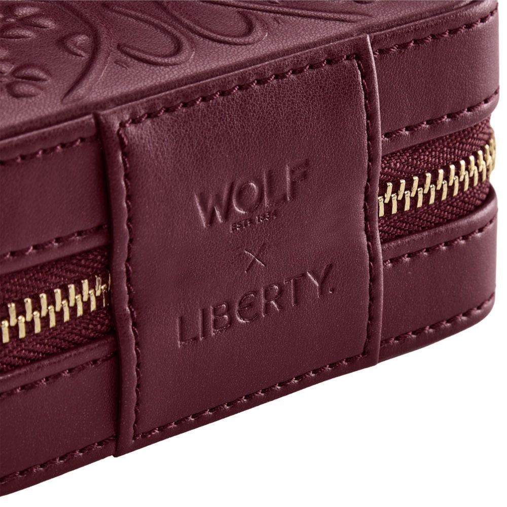 Close-up of a burgundy leather product with 'Wolf' and 'Liberty' branding.