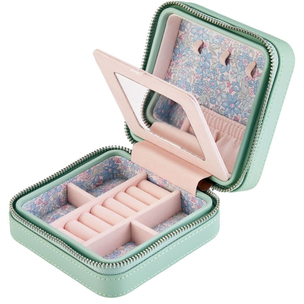 Open jewelry case with pink interior and floral lining on a white background