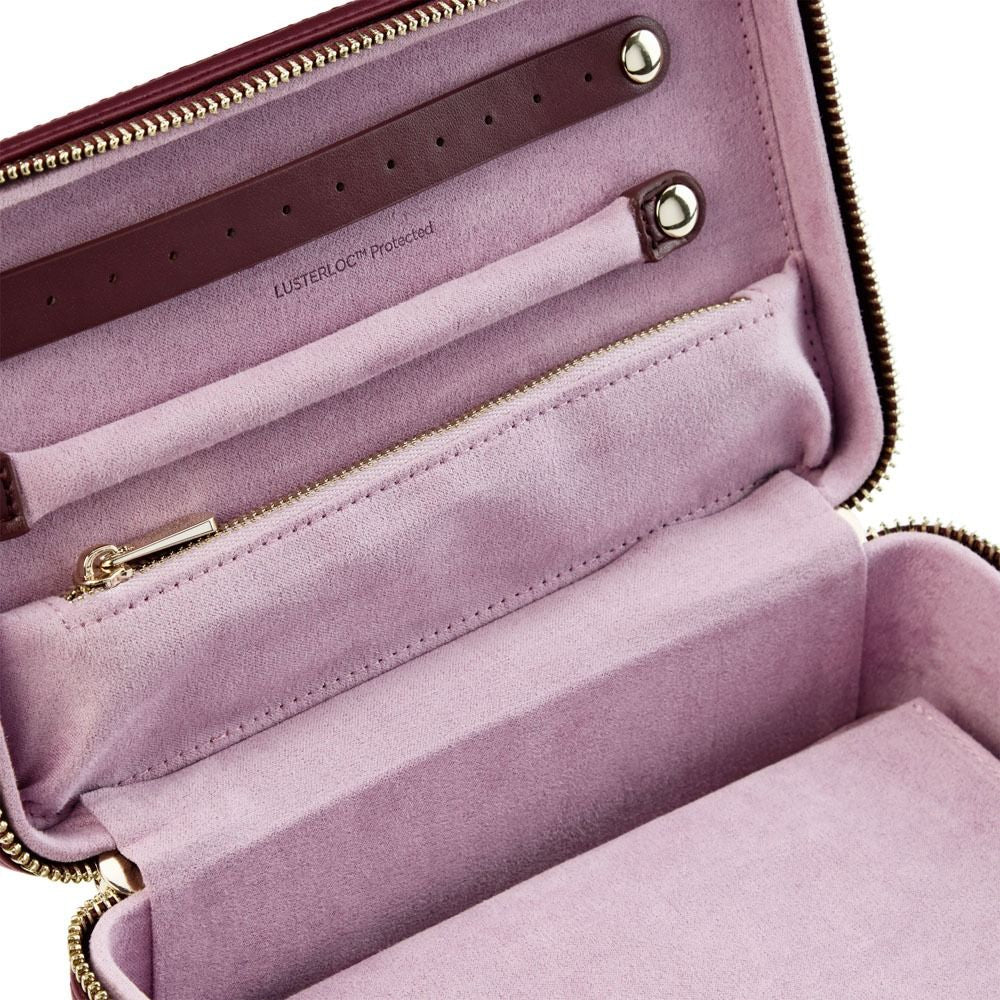 Open pink handbag with gold zippers on a white background