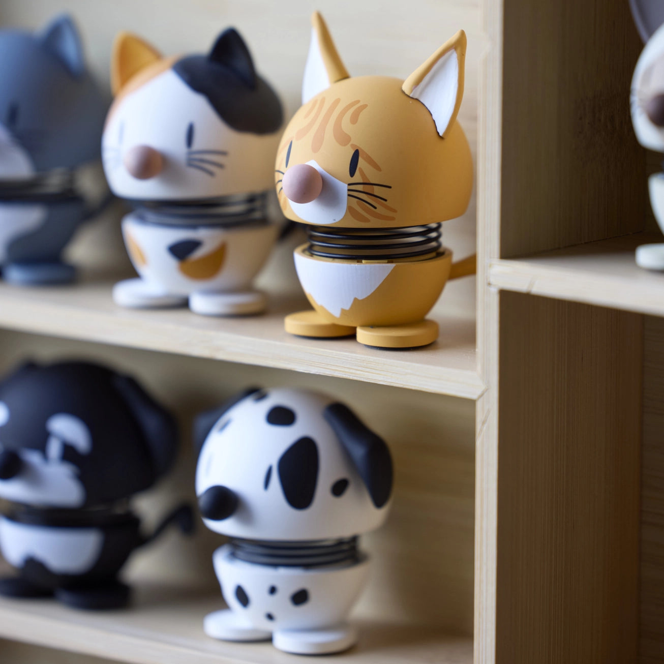 Colorful cat and dog figurines on a wooden shelf