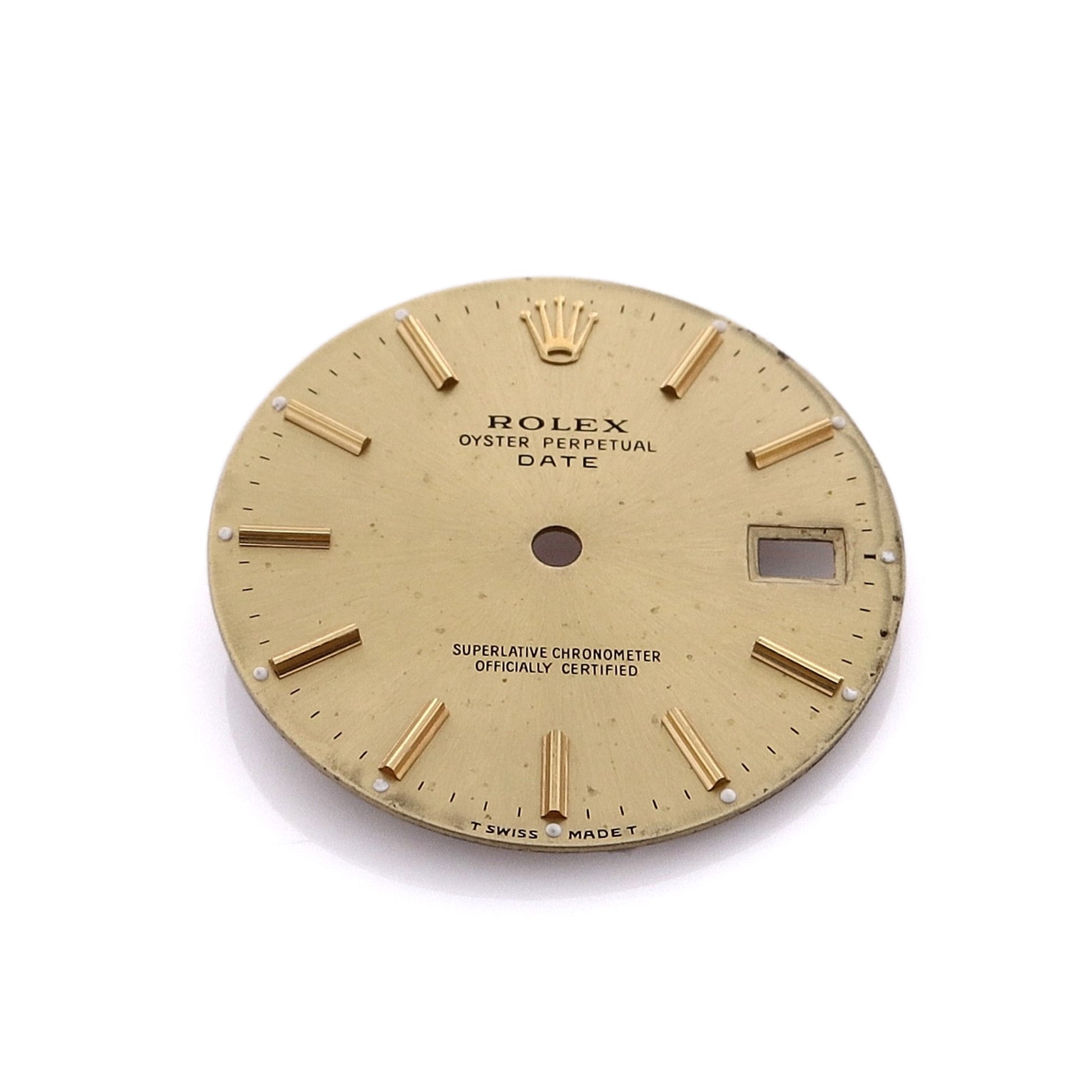 A champagne Rolex watch dial with stick indexes and a date display window.