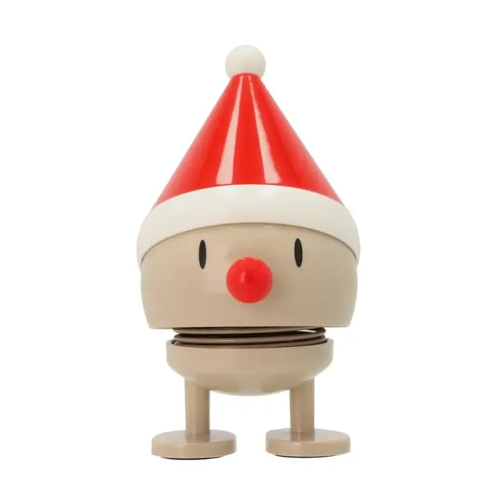A plastic toy figure with a round beige body, black eyes, a red nose, and a red-and-white Santa hat, shown on a plain white background.