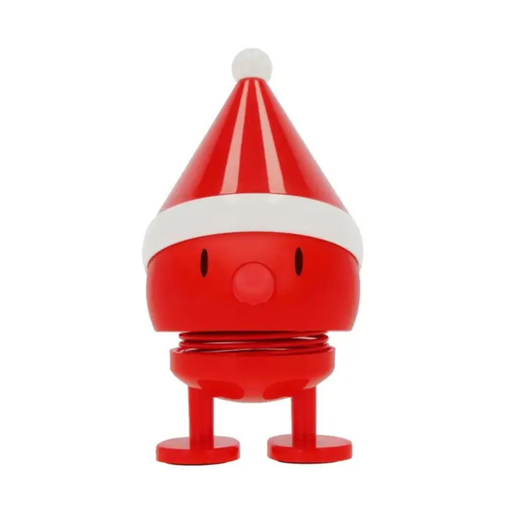 A red and white plastic toy figure shaped like a round character wearing a Santa hat, standing on small round feet against a plain white background.