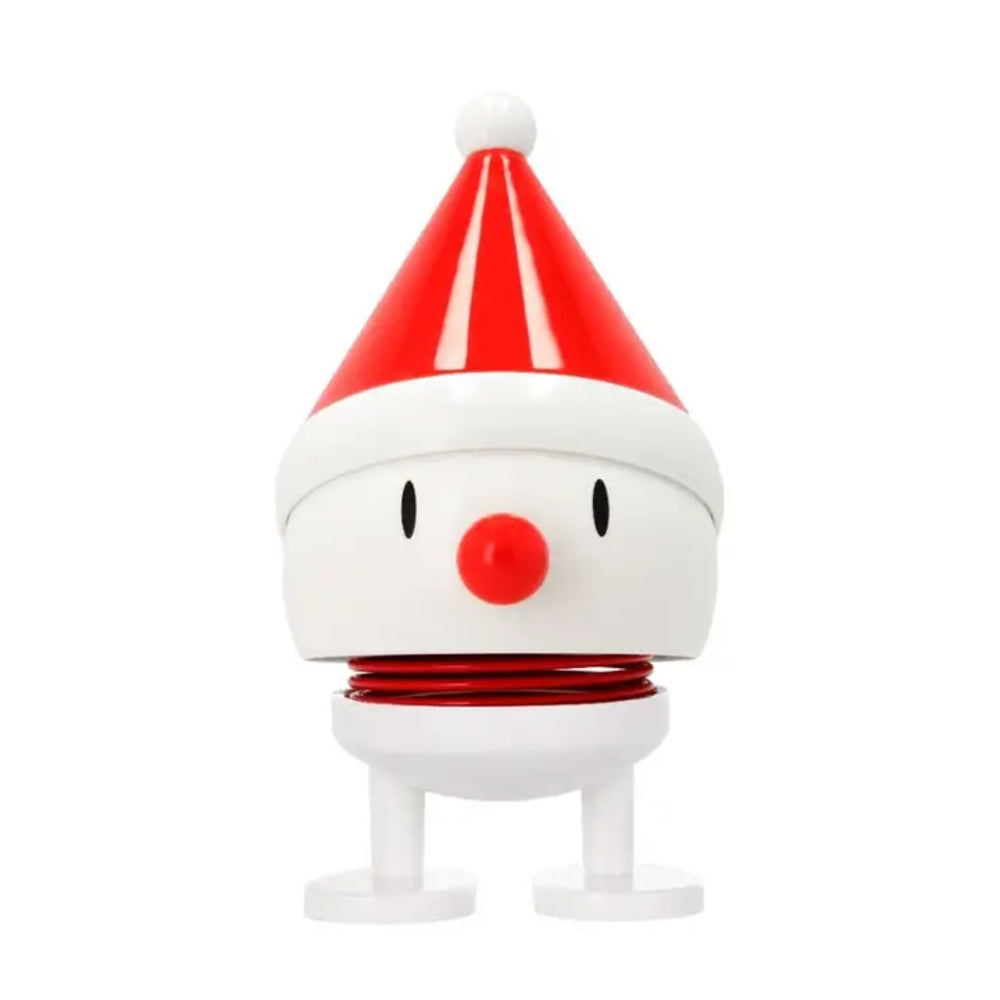 A small white and red Santa hat-shaped plastic toy figurine with a round white body, black dot eyes, a red nose, and a red spring-like band around the neck, shown on a plain white background.