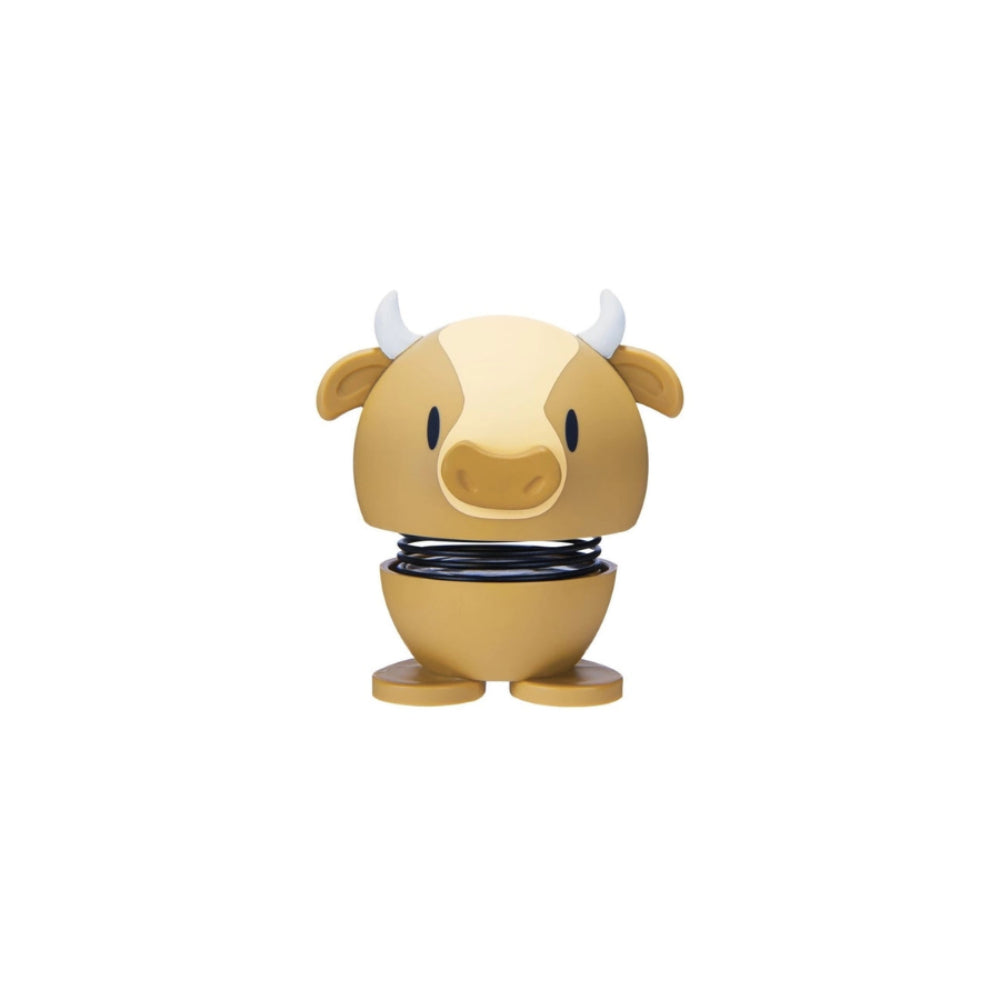 Tan cow shaped figurine with a spring on a white background