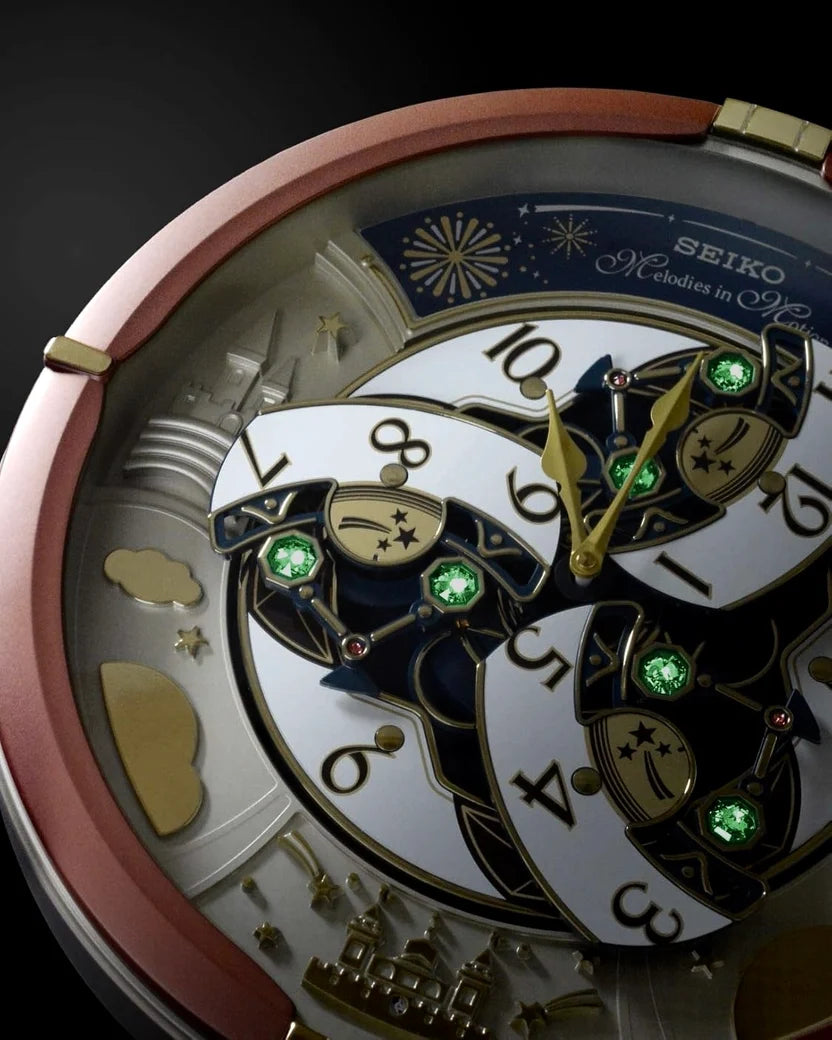 Close-up of a Seiko automatic watch with a white skeleton dial, gold-tone hands and markers, green crystal accents, and a rose gold-toned bezel on a dark background.
