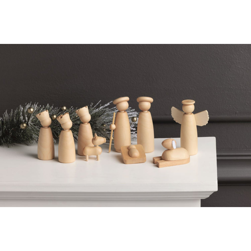 Wooden nativity scene on a white surface with a dark background