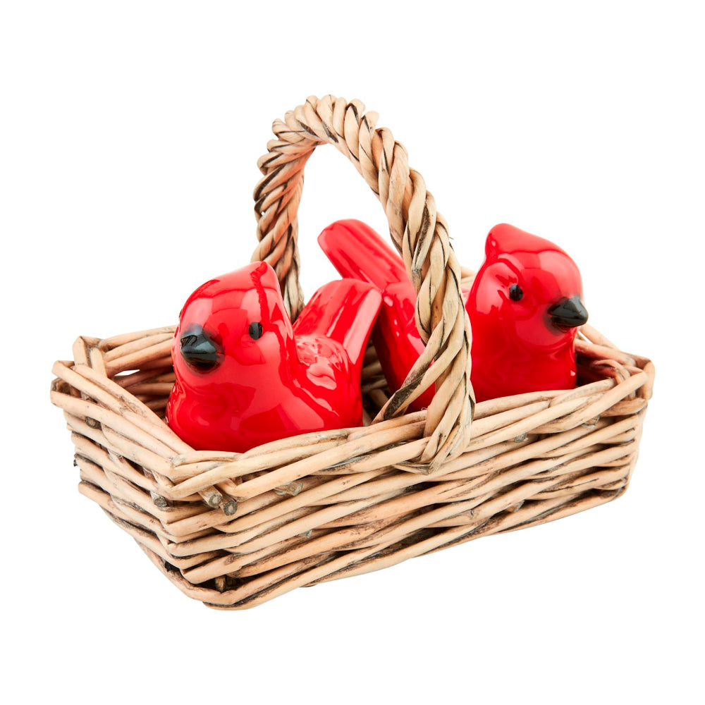 Red cardinal bird figurines in a woven basket on a white background