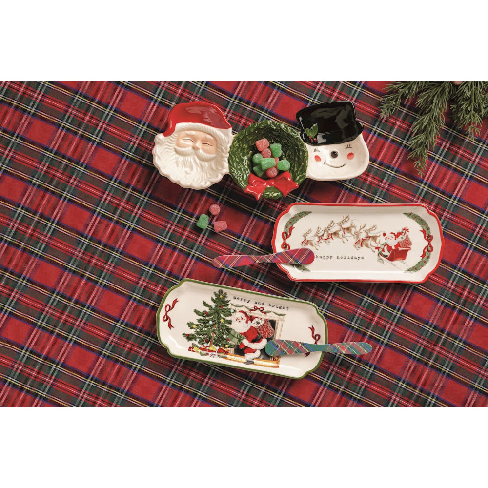 Christmas-themed ceramic plates on a red plaid tablecloth