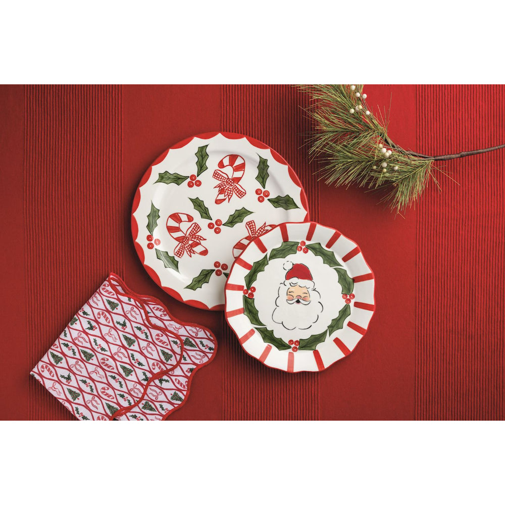 Two Christmas-themed plates with decorative designs on a red surface.