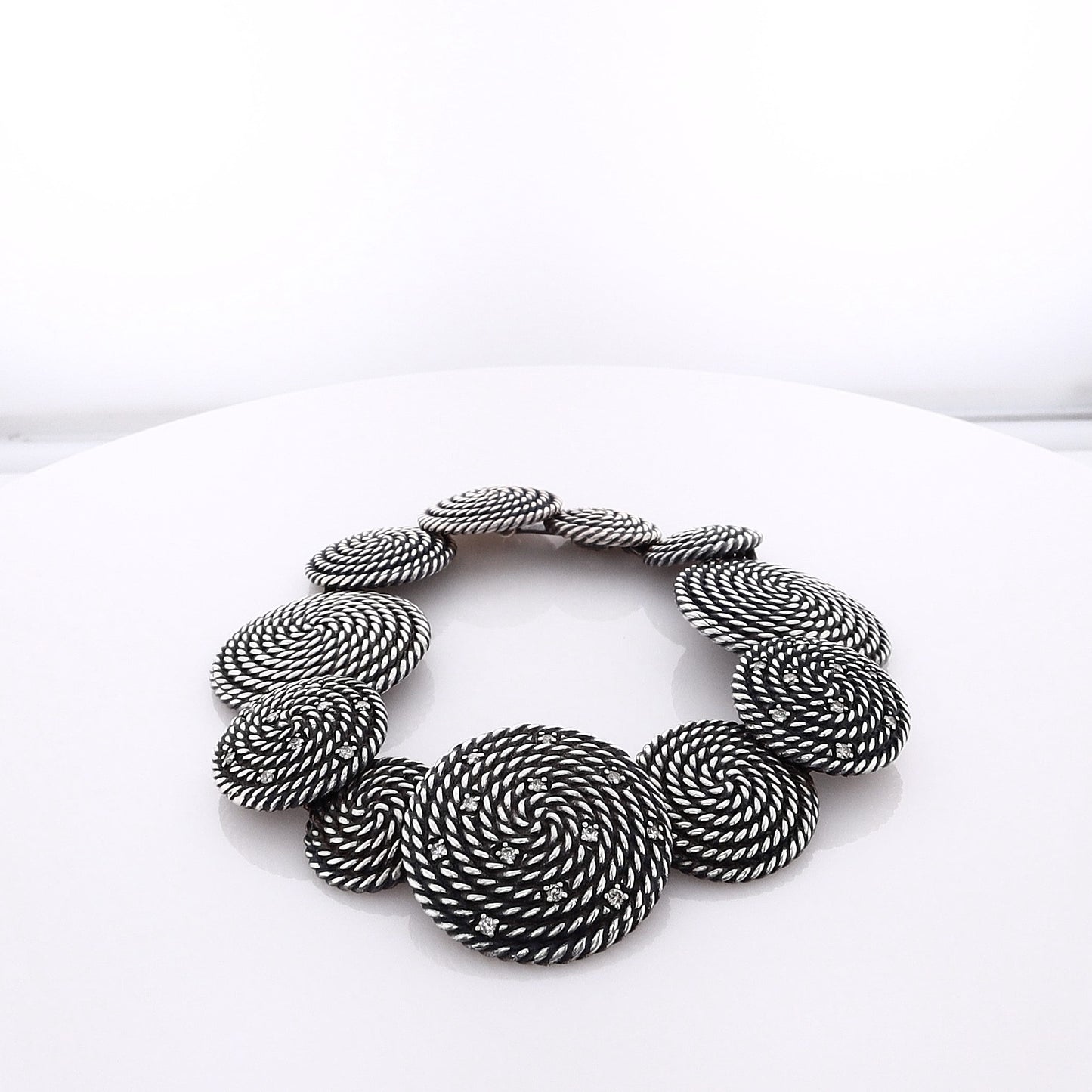 Silver David Yurman bracelet with circular coil links on a white background
