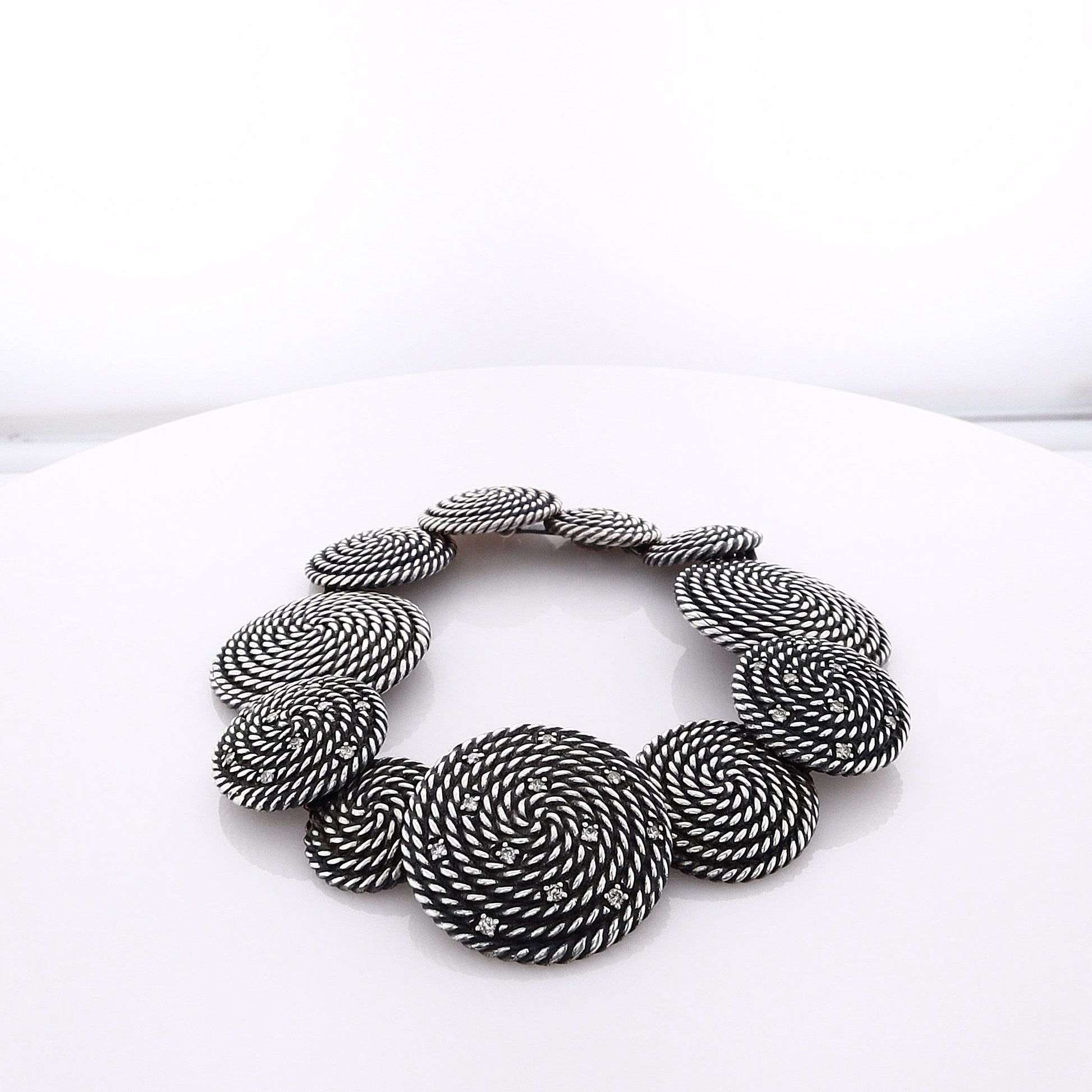 Silver David Yurman bracelet with circular coil links on a white background
