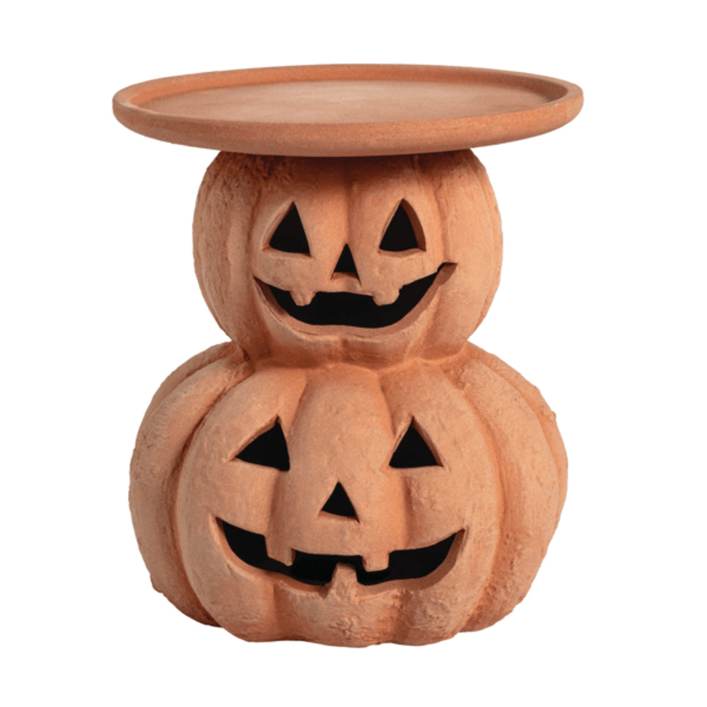 Ceramic pumpkin-shaped candle holder with jack-o'-lantern faces on a white background