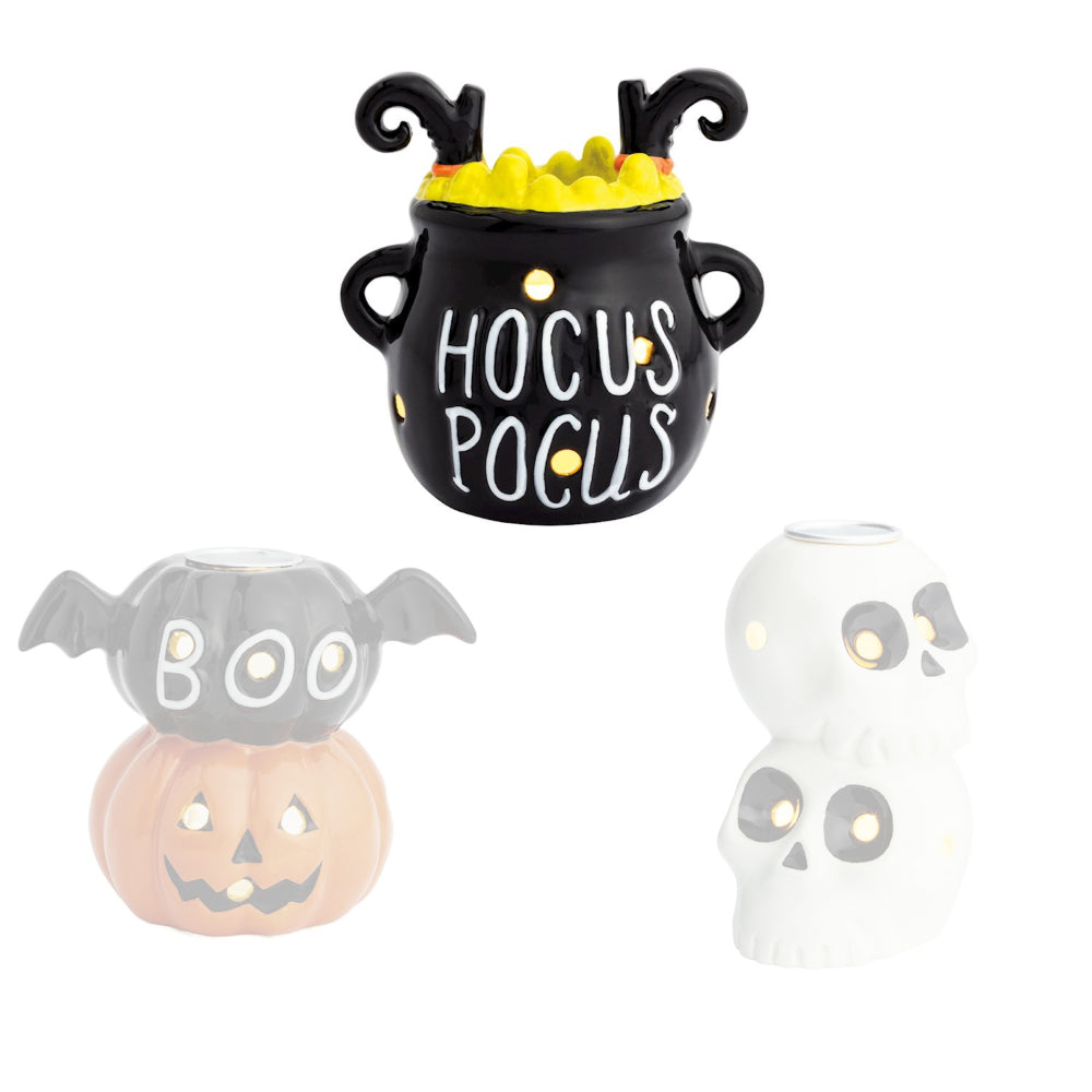 Hocus Pocus halloween-themed decorative candle holder a black cauldron with "Hocus Pocus" and witch legs on a white backround. 