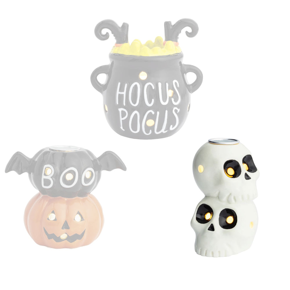 Skeleton halloween-themed candle holder with with two white skulls on top of each other with blackend eyes on a white backround. 