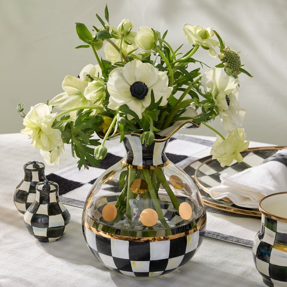 Decorative vase with floral arrangement on a checkered tablecloth