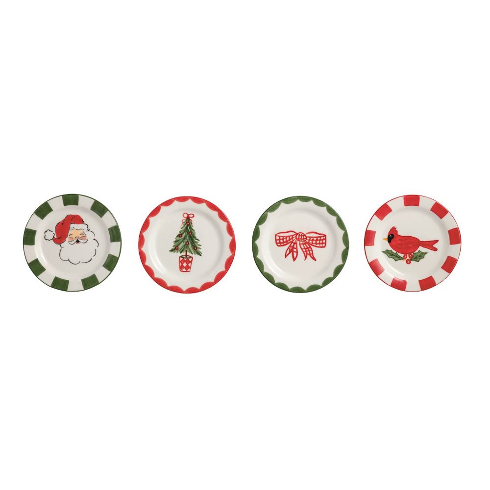 Four small round holiday-themed plates arranged in a row on a white background. From left to right: one with a green-and-white checkered border and a Santa face illustration, one with a red-and-white scalloped border and a Christmas tree with a gift box, one with a green-and-white scalloped border and a red gift box with candy, and one with a red-and-white checkered border and a red cardinal on holly.