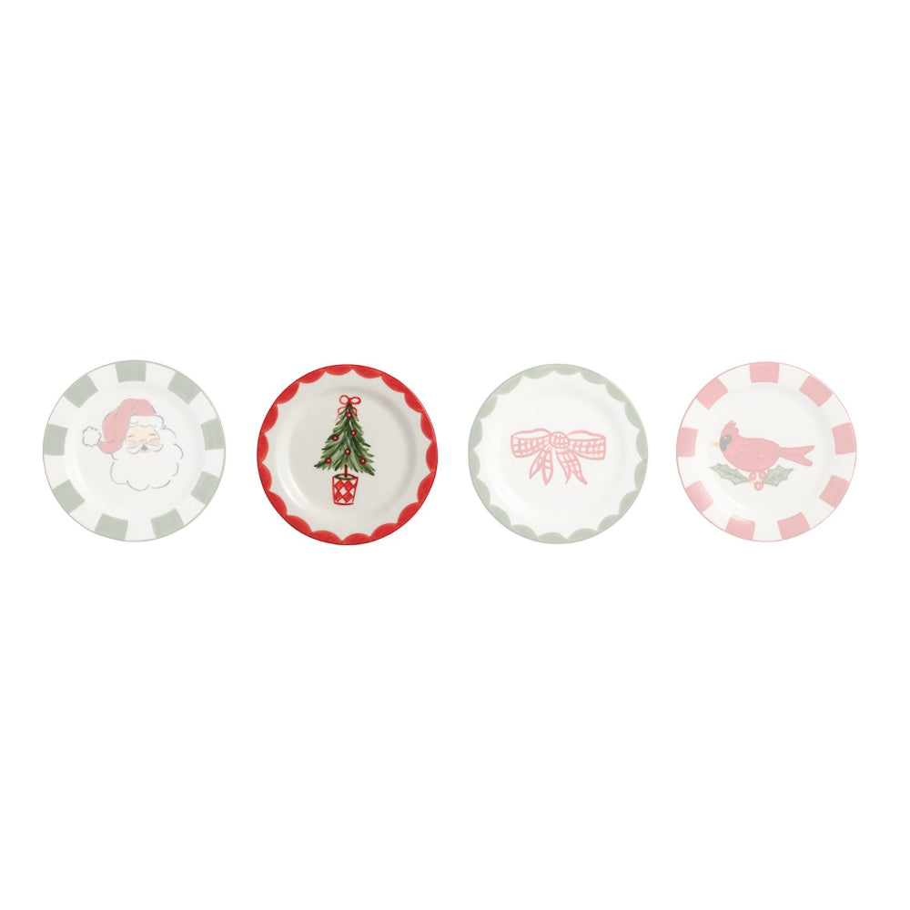 Four small decorative plates arranged in a row on a white background. The plates have scalloped edges and festive holiday designs: a Santa face with pink and white checkers, a Christmas tree with a red border, a pink bow, and a pink bird with pink and white checkers.