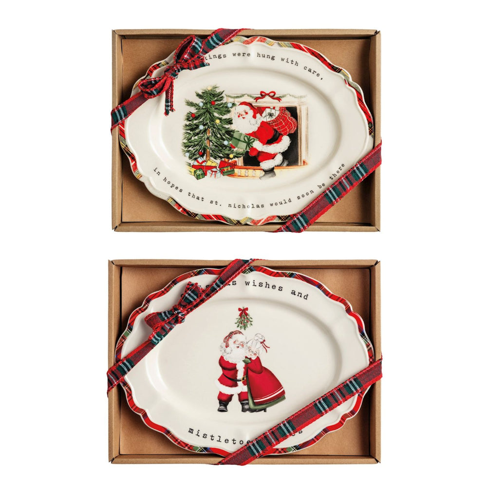 Two Christmas-themed plates with Santa Claus designs in cardboard boxes.