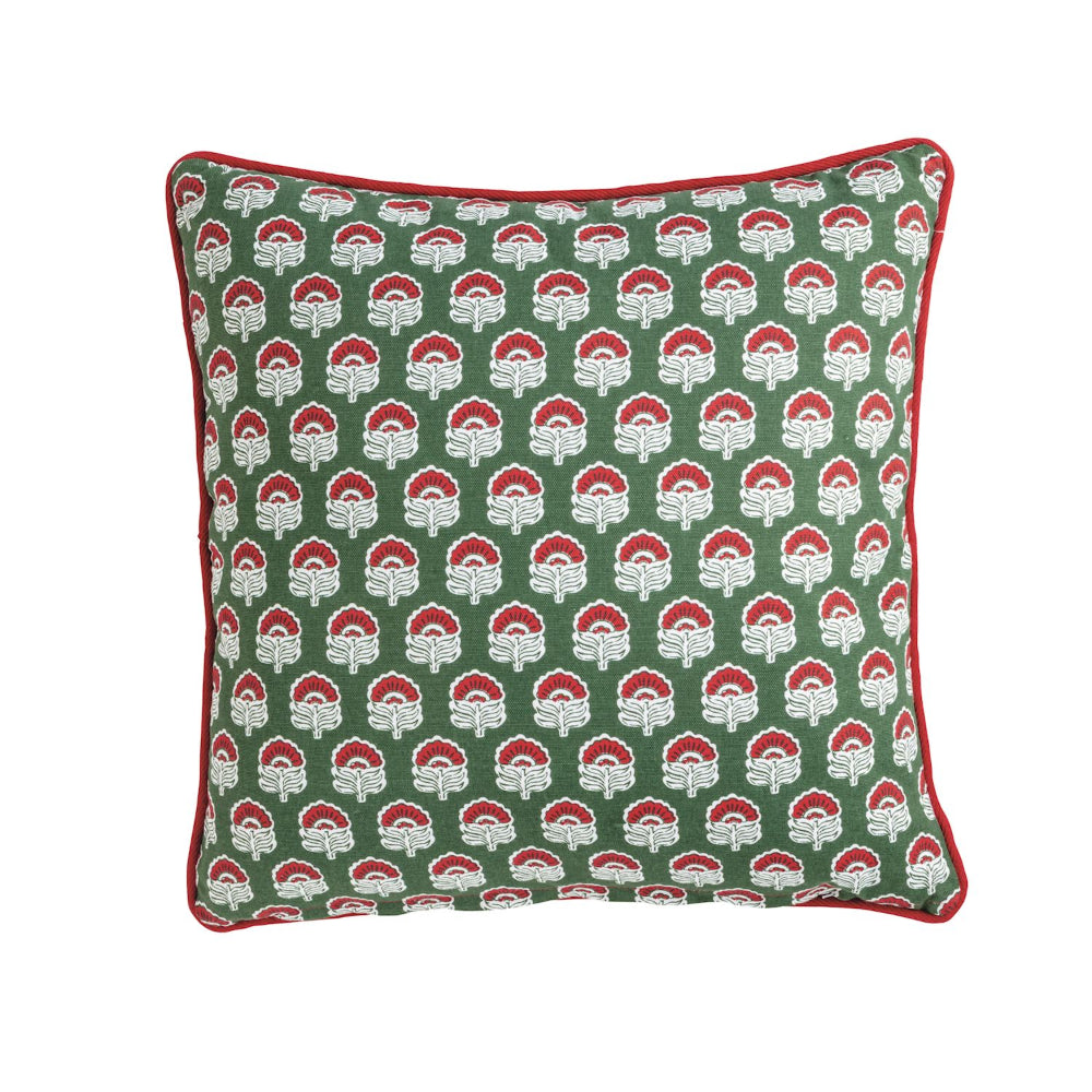 Decorative pillow with red and white floral pattern on a green background
