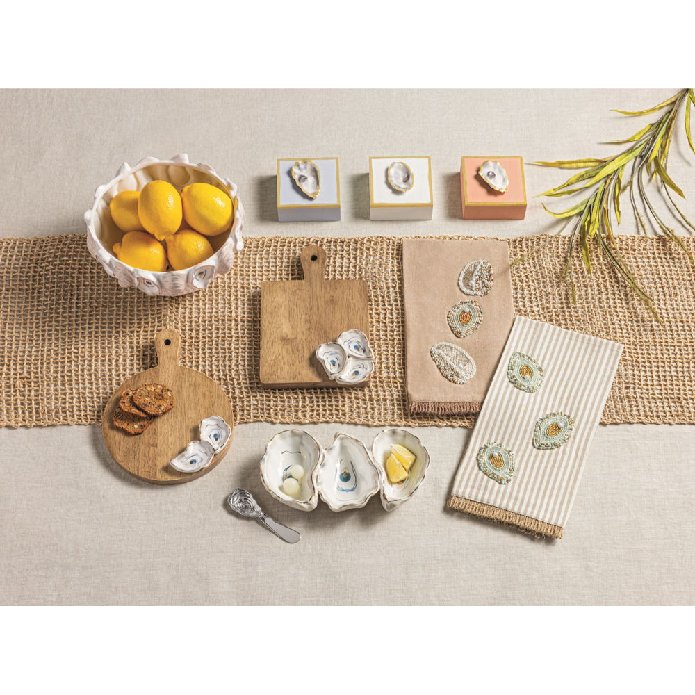 Table setting with oysters, lemons, and decorative items on a neutral background