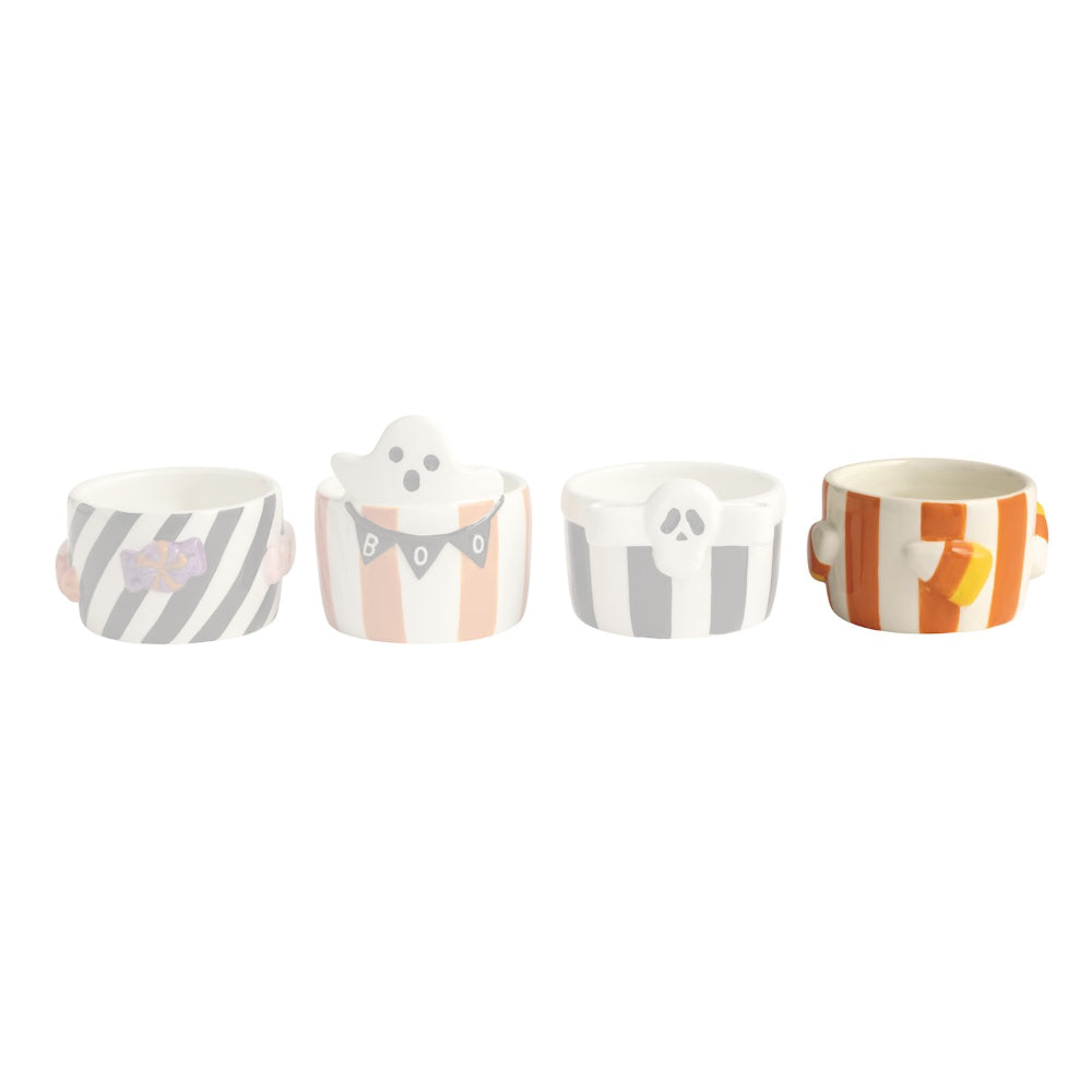 Four small ceramic cups with Halloween-themed designs on a white background
