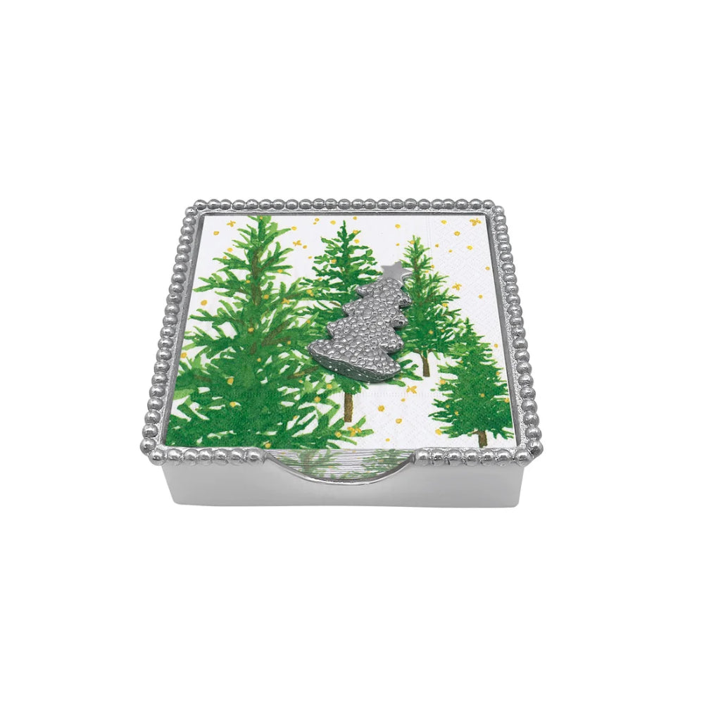 Dotty tree beaded napkin holder with white napkin with a evergreen design and silver tree shaped weight on a white backround. 